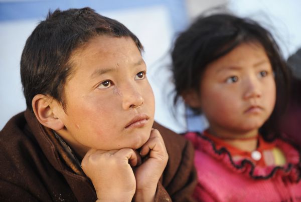 Children of Tibetan ethnic group have their classes inside the temporary classroom at racecourse Gyegu Town of quake-hit Tibetan Autonomous Prefecture of Yushu, northwest China's Qinghai Province, April 25, 2010. 