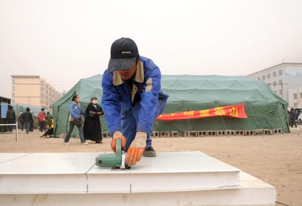 A worker prepares to build prefab houses in quake-hit Tibetan Autonomous Prefecture of Yushu, northwest China's Qinghai Province, April 25, 2010. 