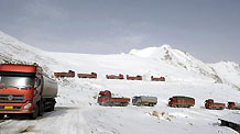 Heavy loaded trucks are stranded by snow near Que'er mount at the north section of the Sichuan-Tibet road on April 25, 2010.