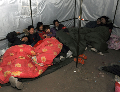 YVolunteers rest in a tent in Yushu, Northwest China's Qinghai Province on April 21, 2010.