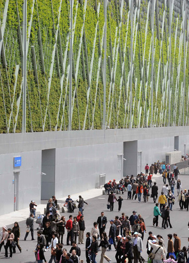 Visitors pass by the Theme Pavilion whose facades are covered by vegetation April 25, 2010.