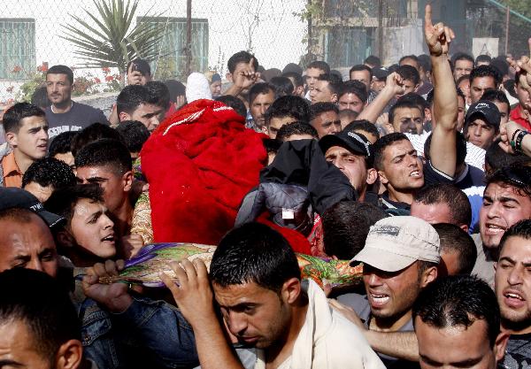 Palestinians carry the body of Hamas militant Ali Al-Sewiti during his funeral in the West Bank village of Beit Awwa, near Hebron April 26, 2010.