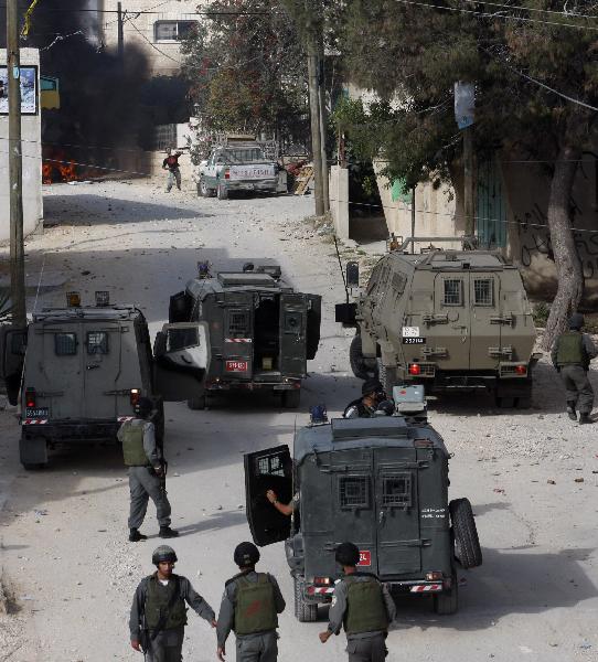 Israeli soldiers take position during clashes with Palestinian protesters in the West Bank village of Beit Awwa, near Hebron April 26, 2010.