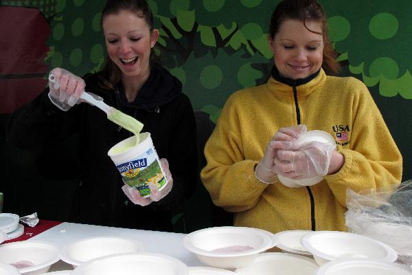 Staffs distribute organic yogurt to local citizens on Union Square in New York, the United States, April 25, 2010.