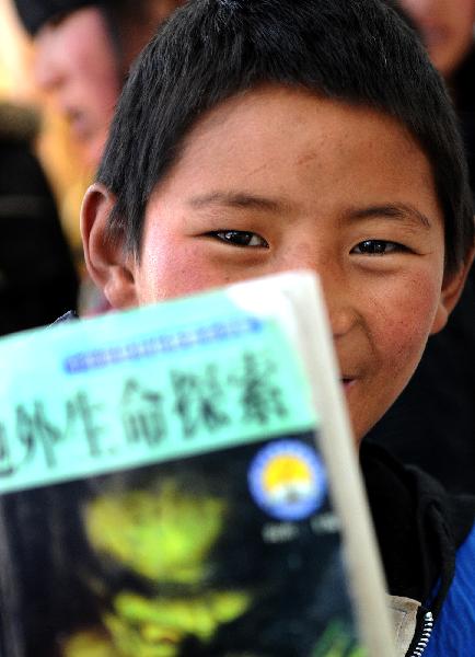 An orphan of ethnic Tibetan group reads a magazine while waiting for an airliner at the airport of Yushu County April 26, 2010. 