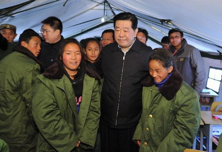 Jia Qinglin (C), chairman of the National Committee of the Chinese People's Political Consultative Conference, visits the local middle school students in quake-hit Yushu County, Qinghai Province, on April 26, 2010. 