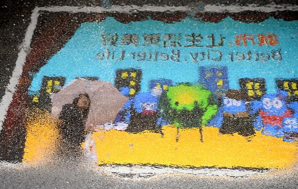 A visitor is reflected in water in the World Expo Park in Shanghai, east China, April 26, 2010.