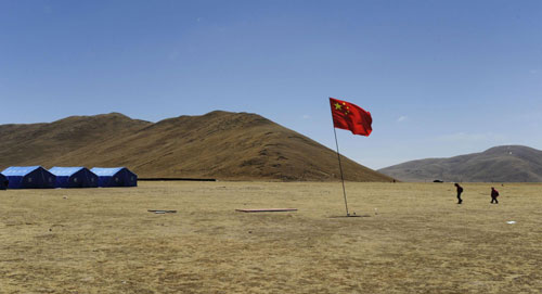 China's national flag flaps in the wind in front of temporary classrooms in the worst-hit Longbao County in Tibet autonomous prefecture of Yushu, Qinghai Province, April 27, 2010. 