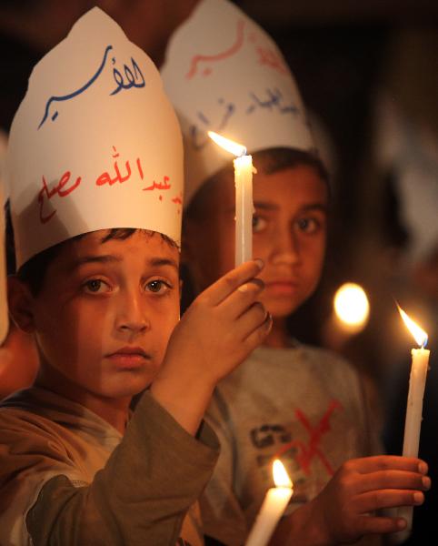Palestinian children hold candles during a protest calling for the release of Palestinian prisoners in Gaza City, Monday, April 26, 2010. 