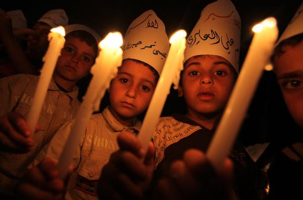 Palestinian children hold candles during a protest calling for the release of Palestinian prisoners in Gaza City, Monday, April 26, 2010. 