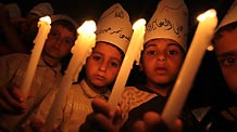 Palestinian children hold candles during a protest calling for the release of Palestinian prisoners in Gaza City, Monday, April 26, 2010.