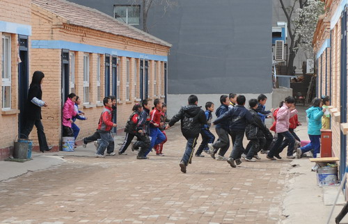 Students run out of the classroom in an earthquake safety drill at a school in Shijingshan district in Beijing, on April 27, 2010. 