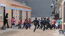 Students run out of the classroom in an earthquake safety drill at a school in Shijingshan district in Beijing, on April 27, 2010.