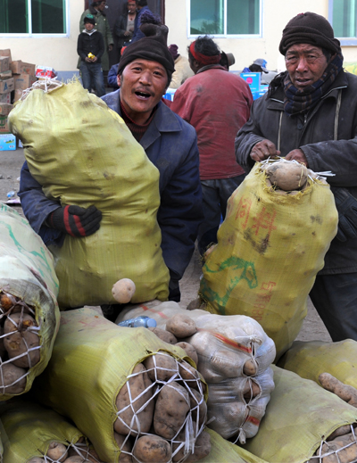 Villagers of Tibetan ethnic group receive distributed relief cakes at Ganda village of Gyegu Town of quake-hit Tibetan Autonomous Prefecture of Yushu, northwest China's Qinghai Province, April 27, 2010.