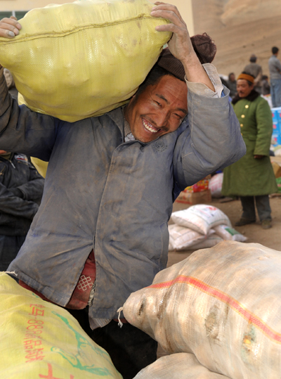 Villagers of Tibetan ethnic group receive distributed relief cakes at Ganda village of Gyegu Town of quake-hit Tibetan Autonomous Prefecture of Yushu, northwest China's Qinghai Province, April 27, 2010.