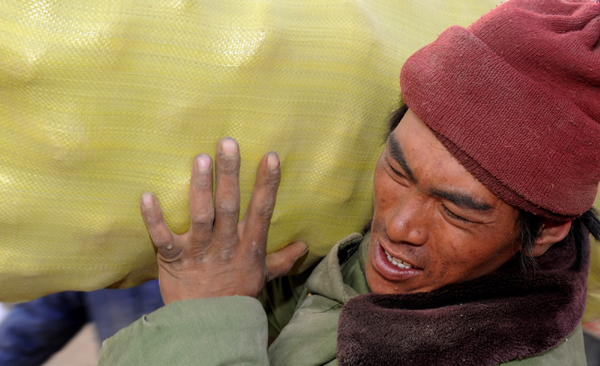 Villagers of Tibetan ethnic group receive distributed relief cakes at Ganda village of Gyegu Town of quake-hit Tibetan Autonomous Prefecture of Yushu, northwest China's Qinghai Province, April 27, 2010.