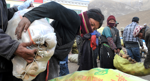 Villagers of Tibetan ethnic group receive distributed relief cakes at Ganda village of Gyegu Town of quake-hit Tibetan Autonomous Prefecture of Yushu, northwest China's Qinghai Province, April 27, 2010.