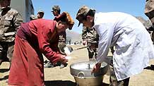 A soldier delivers food to a Buddhist nun on April 27, 2010.