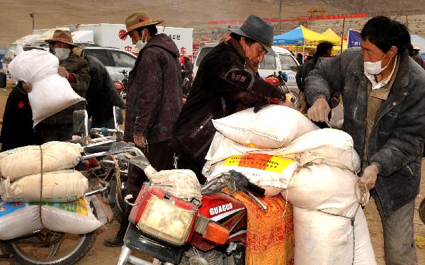 Local residents recieve flour and rice in Gyegu Town in quake-hit Yushu County, northwest China's Qinghai Province, April 28, 2010.