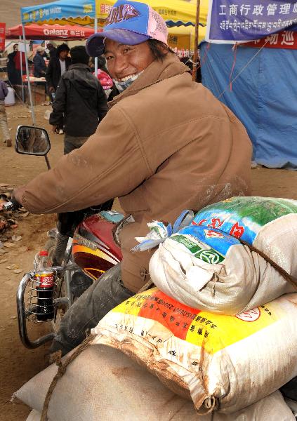 A Tibetan man recieves rice in Gyegu Town in quake-hit Yushu County, northwest China's Qinghai Province, April 28, 2010. 