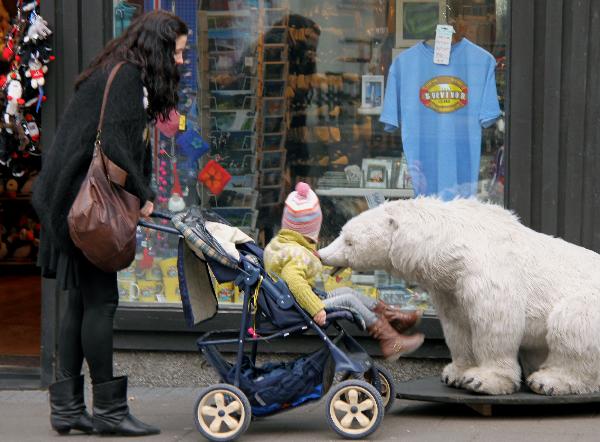 A woman pushes her kid in a baby carriage in Reykjavik, capital of Iceland, April 28, 2010.