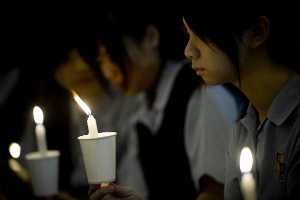 Students attend a memorial service to honor Wong Fu-wing, a volunteer from Hong Kong who lost his life when rescuing others during the Yushu quake in southwest China's Qinghai Province, in Hong Kong, south China, April 28, 2010. 