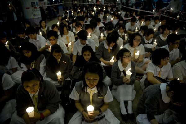 Students attend a memorial service to honor Wong Fu-wing, a volunteer from Hong Kong who lost his life when rescuing others during the Yushu quake in southwest China's Qinghai Province, in Hong Kong, south China, April 28, 2010. 