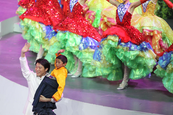Jangba Tsering (R), an orphan who survived the Yushu earthquake that shook a Tibetan area of northwest China's Qinghai Province on April 14 waves to spectators during the performance of opening ceremony for the 2010 Shanghai World Expo at the Expo Cultural Center in Shanghai, east China, April 30, 2010.