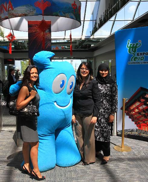 Visitors pose for photos with the Shanghai World Expo mascot 'Haibao' at a photo exhibition on the Shanghai World Expo 2010, in Toronto, Canada, May 3, 2010. 