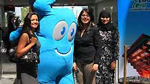 Visitors pose for photos with the Shanghai World Expo mascot 'Haibao' at a photo exhibition on the Shanghai World Expo 2010, in Toronto, Canada, May 3, 2010.