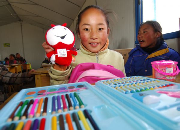 A girl shows a doll from a 'love package' at an orphans' school in quake-hit Yushu Tibetan Autonomous Prefecture of northwest China's Qinghai Province, on May 5, 2010. Each of 229 students of the school received a donated 'love package' including stationery and toy on Wednesday.