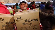 Student Zhoema holds a 'love package' at an orphans' school in quake-hit Yushu Tibetan Autonomous Prefecture of northwest China's Qinghai Province, on May 5, 2010.