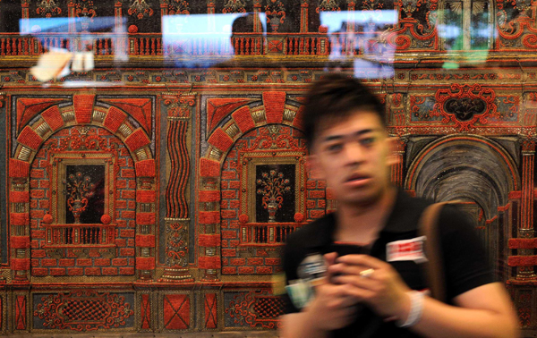 A tourist views silk embroideries at Italy Pavilion in the World Expo Park in Shanghai, east China, on May 3, 2010.