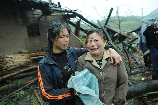 Two women losing relatives in the disaster cry by the remains of destroyed houses at Libai Village of Shaping Town in Dianjiang County, southwest China's Chongqing Municipality, May 6, 2010. 
