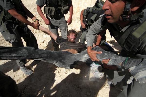 Israeli soldiers detain a protester during a demonstration by Palestinian and foreign peace activists against Israel&apos;s controversial separation barrier in the West Bank village of Walajeh, near Bethlehem, May 6, 2010. 