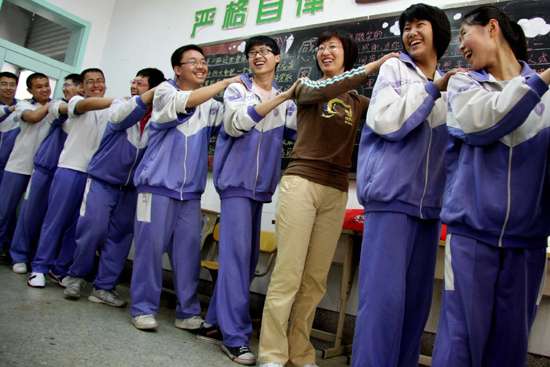 A teacher (3rd right) and her students play game together to help students get relaxed as they undergo the intensive preparation for the national college entrance examination at a high school in Jinan, East China's Shandong Province, May 6, 2010.