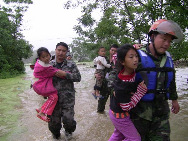 People are helped to transfer to safe places in Yingde City, south China&apos;s Guangdong Province, May 7, 2010. Heavy rainstorm hit Guangdong Province from Wednesday has left six people dead and three others missing up to 1:00 PM local time on Friday and over 50,000 people have been transferred to safe places.