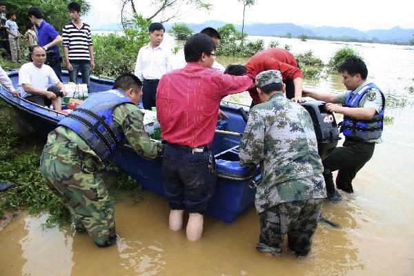 People are helped to transfer to safe places in Yingde City, south China&apos;s Guangdong Province, May 7, 2010. Heavy rainstorm hit Guangdong Province from Wednesday has left six people dead and three others missing up to 1:00 PM local time on Friday and over 50,000 people have been transferred to safe places.