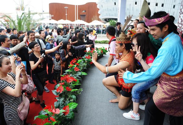 Visitors pose for a group photo with performers of the Malaysia Pavilion at the World Expo Park in Shanghai, east China, May 8, 2010.