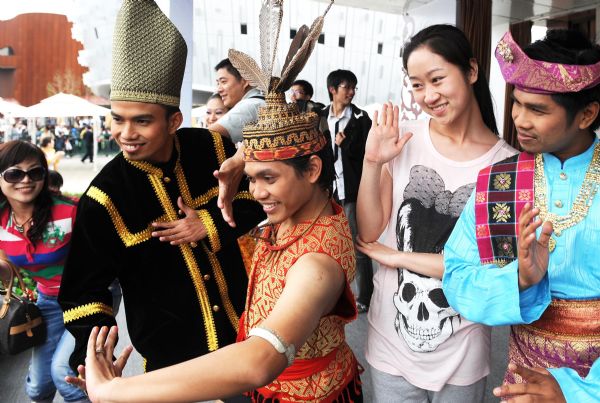 Visitors pose for a group photo with performers of the Malaysia Pavilion at the World Expo Park in Shanghai, east China, May 8, 2010. 