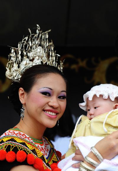 An actress of the Malaysia Pavilion holds a baby in her arms at the World Expo Park in Shanghai, east China, May 8, 2010.