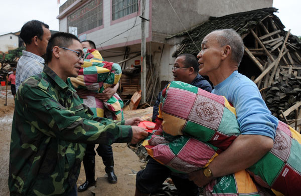 Villagers receive relief materials in Tianxin Village, Egong Town of Dingnan County in east China&apos;s Jiangxi Province, May 7, 2010. Seven people were dead and five were missing after floods and landslides wreaked havoc in Jiangxi over the past two days.
