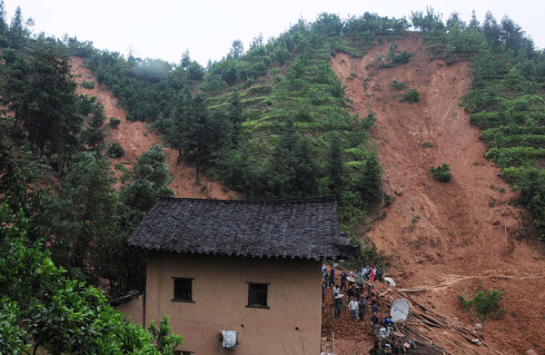Photo taken on May 7, 2010 shows the scene of landslide in Tianxin Village, Egong Town of Dingnan County in east China&apos;s Jiangxi Province. Seven people were dead and five were missing after floods and landslides wreaked havoc in Jiangxi over the past two days.