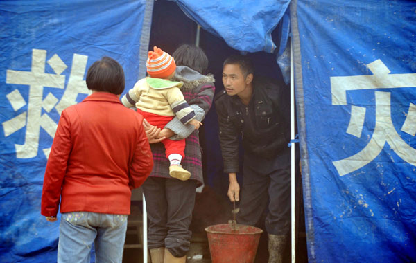 People rest in a tent in Fengjia Township of Xinhua County, central China&apos;s Hunan Province, May 7, 2010. Heavy rain from Wednesday night in some parts of Hunan Province has triggered geological accidents, including landslides and mud flows and left 10 people dead and three missing as of Friday noon. 