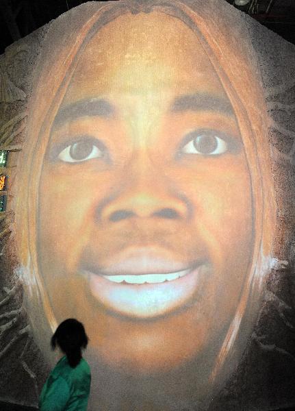 A visitor watches a picture with a smiling face on a wall of the United African Pavilion at the 2010 World Expo site in Shanghai May 9, 2010.