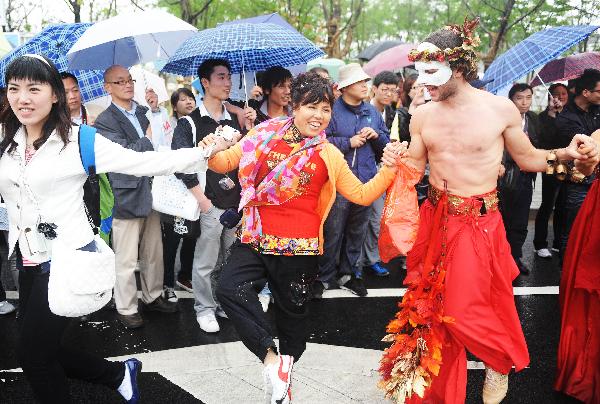 Visitors dance with a performer at the 2010 World Expo site in Shanghai May 9, 2010. A parade was held to mark the European Day special celebrations on Sunday at the 2010 World Expo.