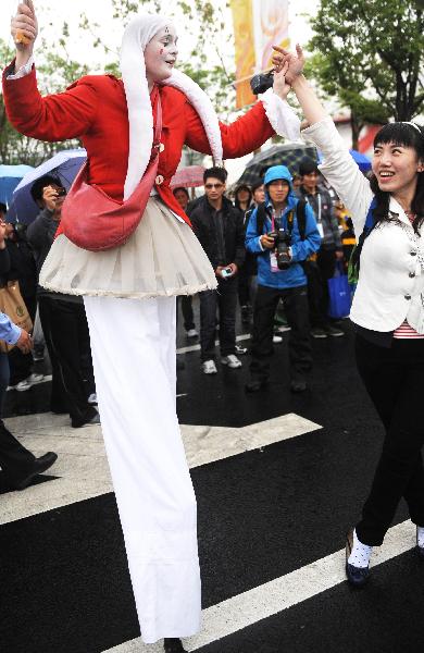 A visitor dances with a performer at the 2010 World Expo site in Shanghai May 9, 2010. A parade was held to mark the European Day special celebrations on Sunday at the 2010 World Expo.
