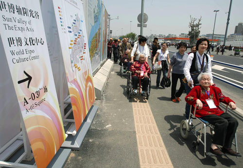 Three centenarians (on wheelchairs), whose cataract disease was cured with the support of the Life and Sunshine Pavilion, visit the China Pavilion on Monday. 