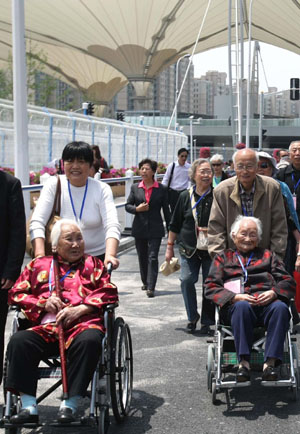 Centenarians (on wheelchairs), whose cataract disease was cured with the support of the Life and Sunshine Pavilion, visit the China Pavilion on Monday. 