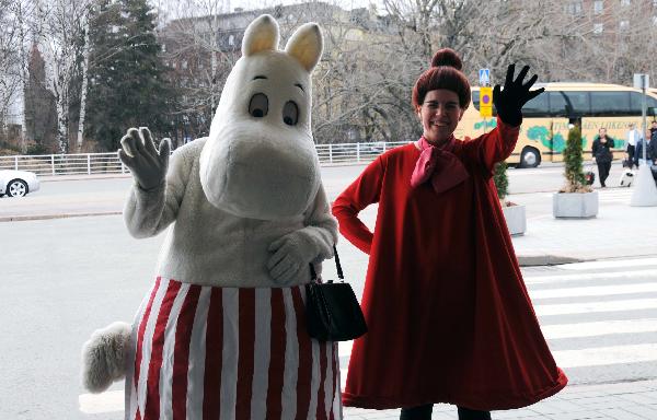 People dressed up as the cartoon figure Muumi pose for photos in Helsinki, Finland, April 17, 2010. 